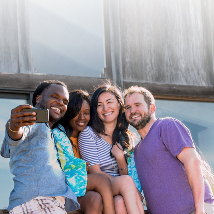 Grupo de 4 personas tomándose un selfie