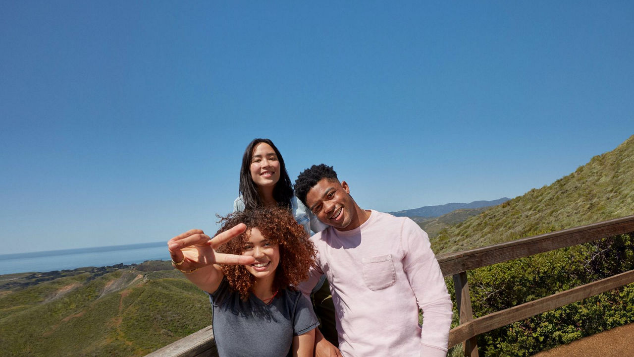 Grupo de tres personas posando para una foto en una montaña