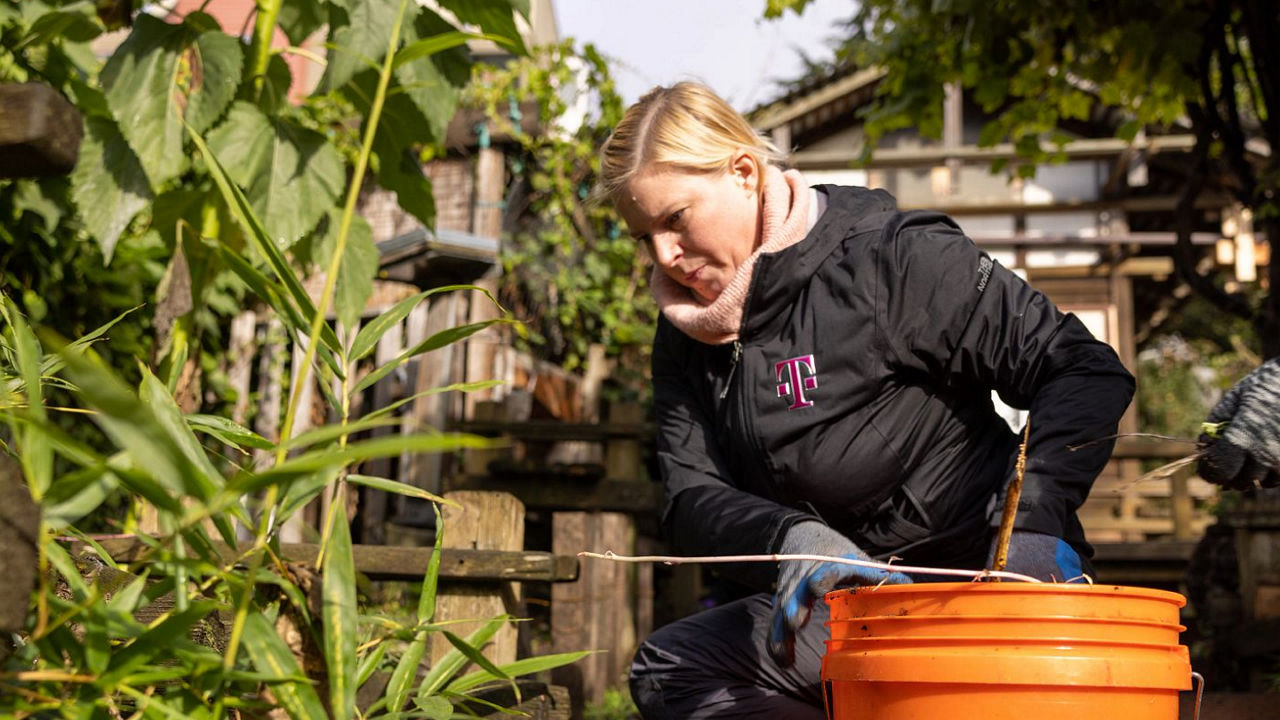 Persona con chaqueta de T-Mobile haciendo trabajo de jardinería