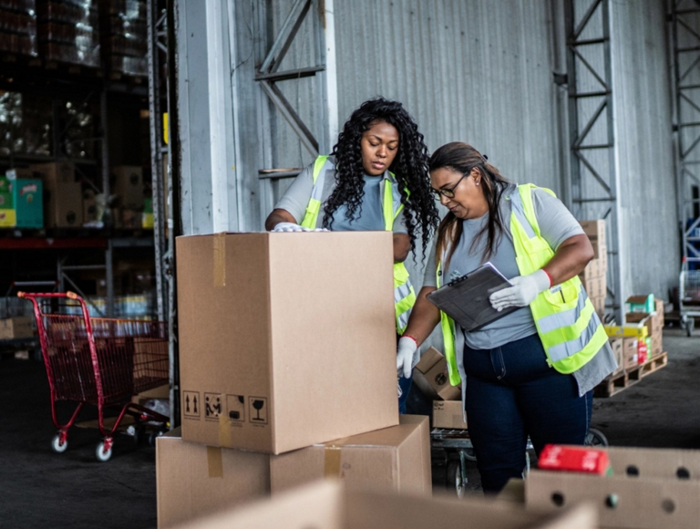 Dos empleados de T-Mobile preparando una caja para envío