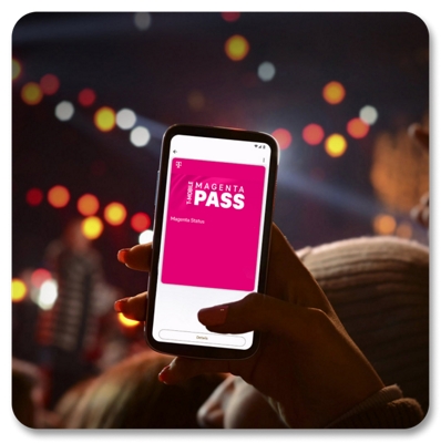 Una mujer en un concierto sostiene su teléfono mostrando Magenta Pass.