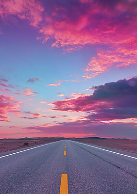 Una carretera con un cielo teñido de color magenta
