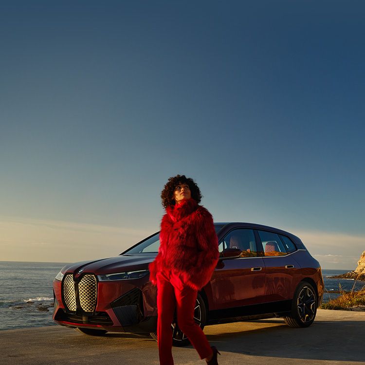 A woman in front of a BMW iX.