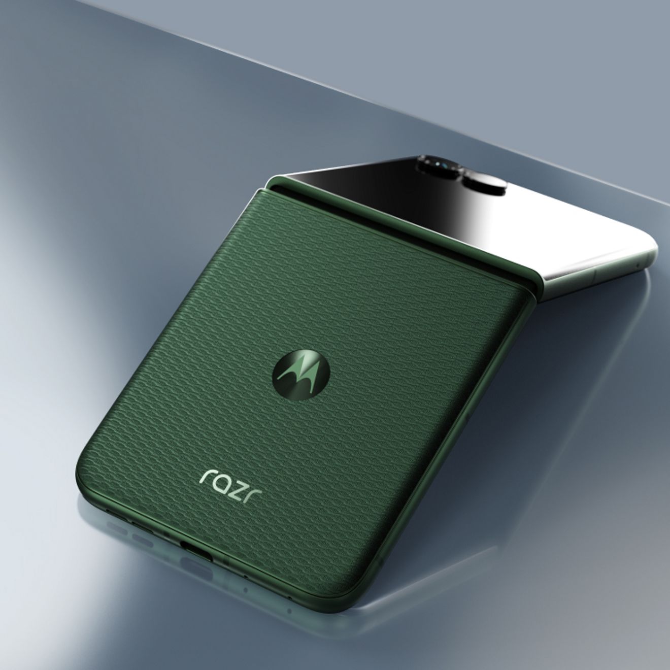 Un motorola razr en color PANTONE® Mountain View se muestra parcialmente plegado, destacando su acabado texturizado inspirado en los tejidos y su diseño compacto plegable.