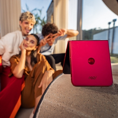 ​Tres personas posan para un selfie frente a un razr+ plegado.​