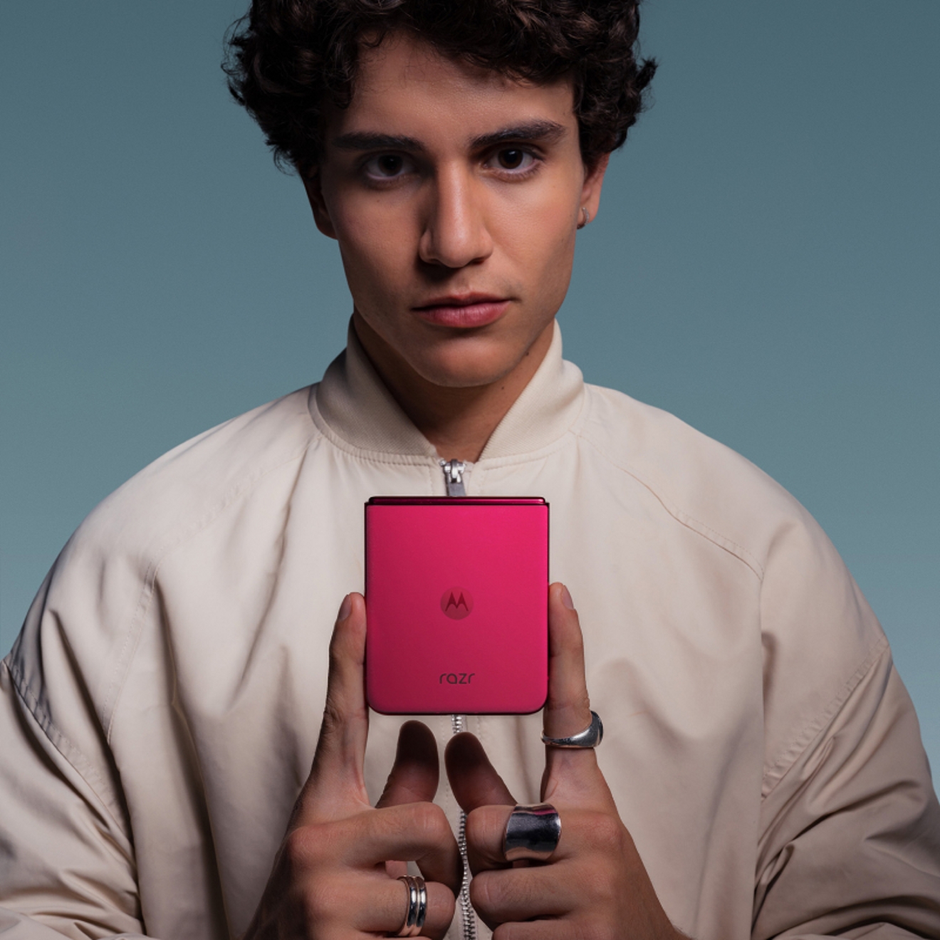 Persona joven demostrando lo compacto que es su Motorola razr plus sujetándolo solo con dos dedos.