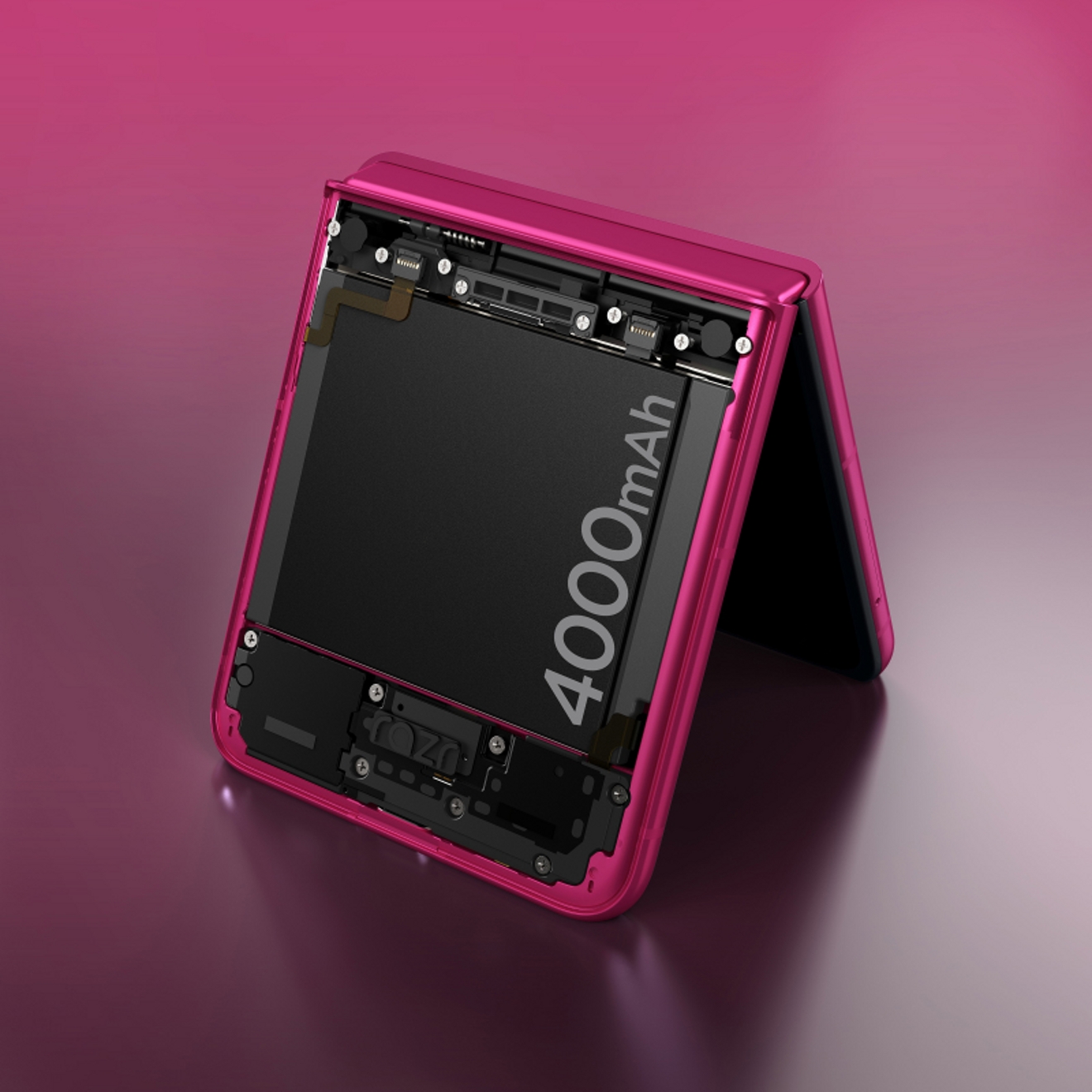 Motorola razr plus en acabado pavo real rosa, parcialmente plegado y apoyado sobre una mesa.