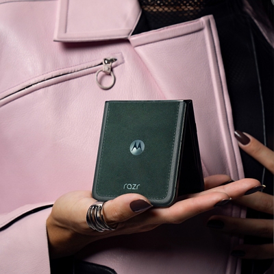 Persona con chaqueta de cuero rosa balanceando su motorola razr ultra plegado en una mano.