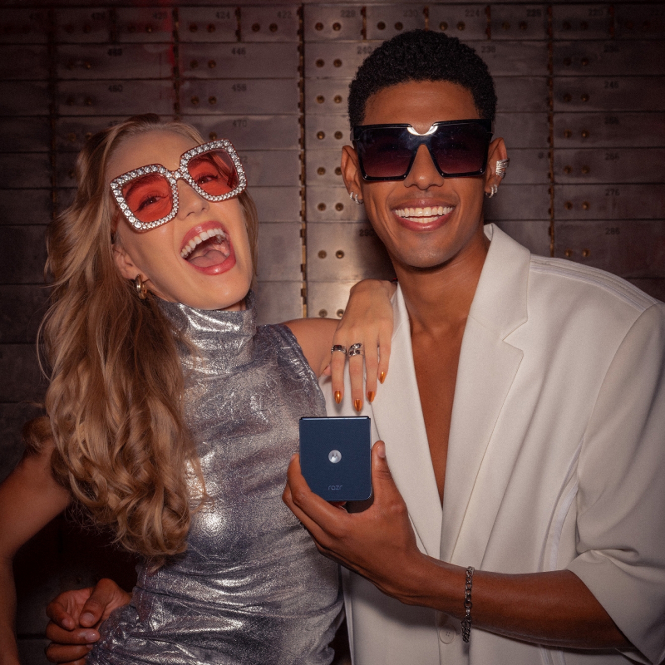 Pareja tomandose divertidos selfies con un motorola razr en una fiesta.