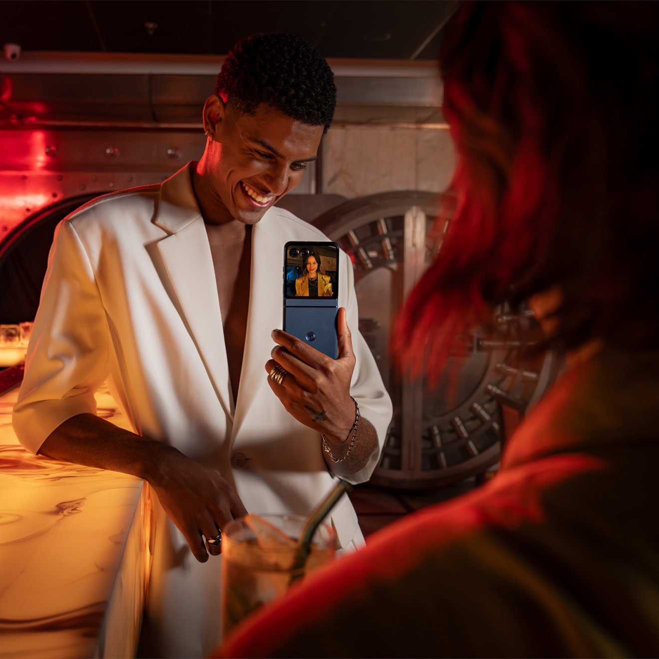 Persona sosteniendo un Motorola razr para compartir una foto de un amigo en la pantalla exterior.