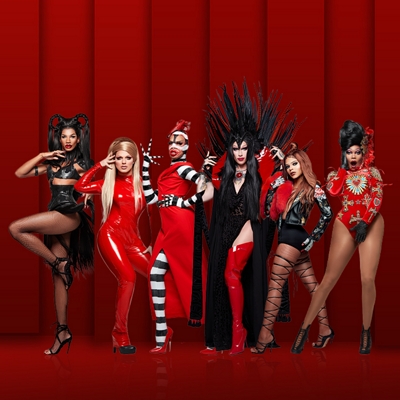 Varios participantes de Ru Paul's Drag Race posan para la cámara con trajes negros, blancos y rojos.