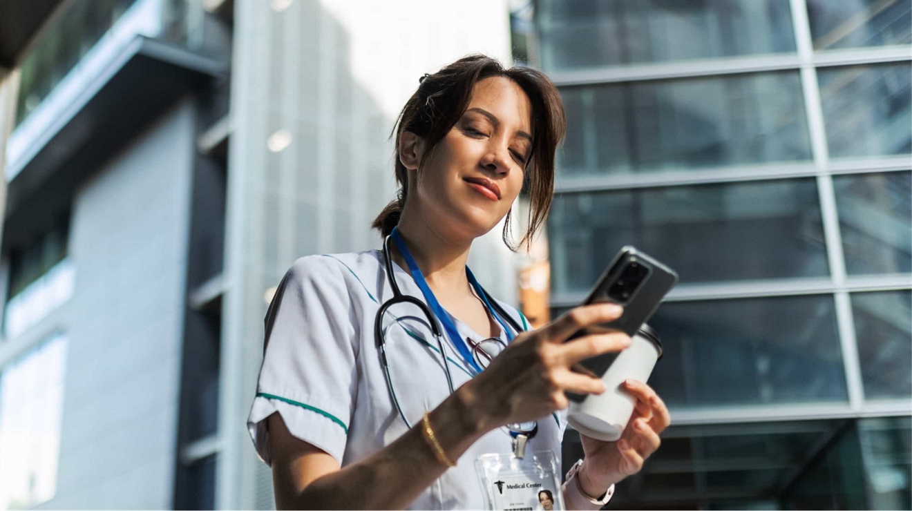 Un médico revisa las últimas novedades en su teléfono fuera del hospital.