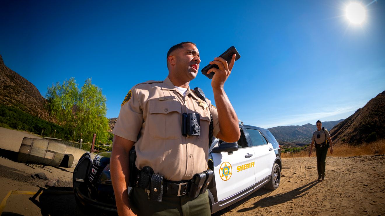 Un agente del sheriff se conecta a través de un smartphone seguro desde el lugar de un incidente en una zona rural.