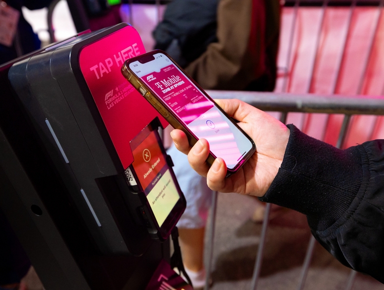 Alguien acercando su teléfono a un lector de boletos.