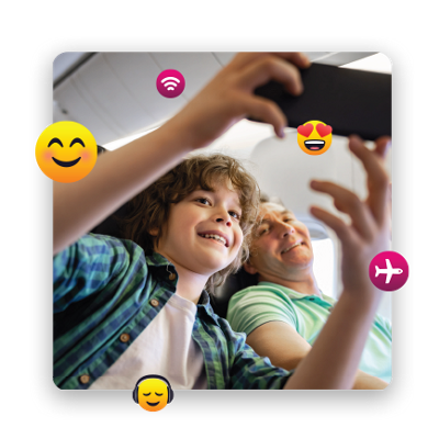 Niño en un avión que le muestra a su papá algo en el teléfono.