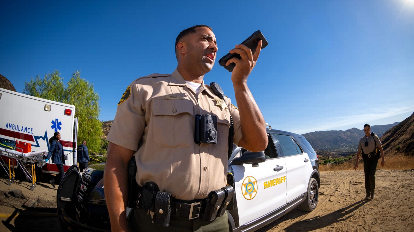 Un agente del sheriff se conecta a través de su smartphone desde el lugar de un incidente en una zona rural.