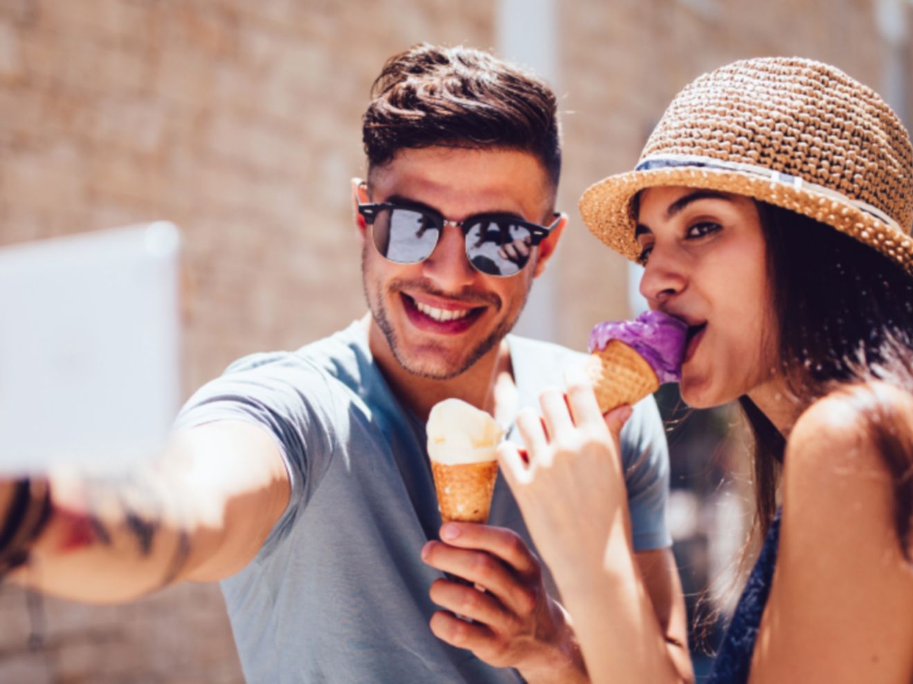 Un hombre y una mujer tomándose un selfie con un smartphone