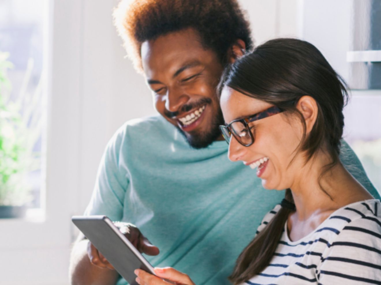 Un hombre y una mujer mirando una tablet.