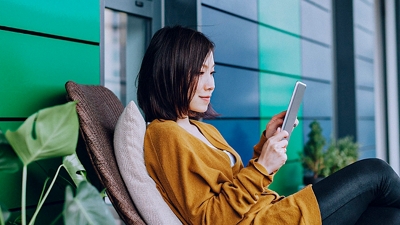 Mujer se relaja en el porche con su tablet.