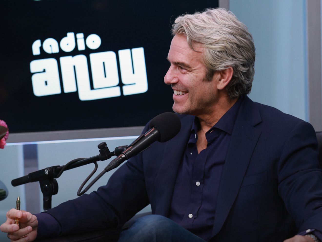 Hombre sentado y sonriendo en un podcast
