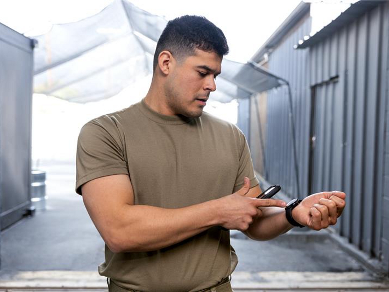 Soldado sosteniendo el teléfono y señalando su reloj
