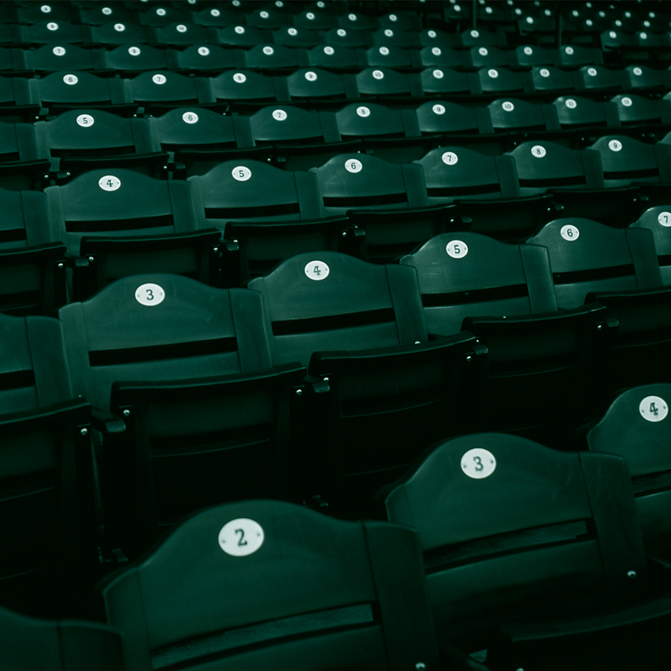 Asientos verdes de un estadio como fondo.