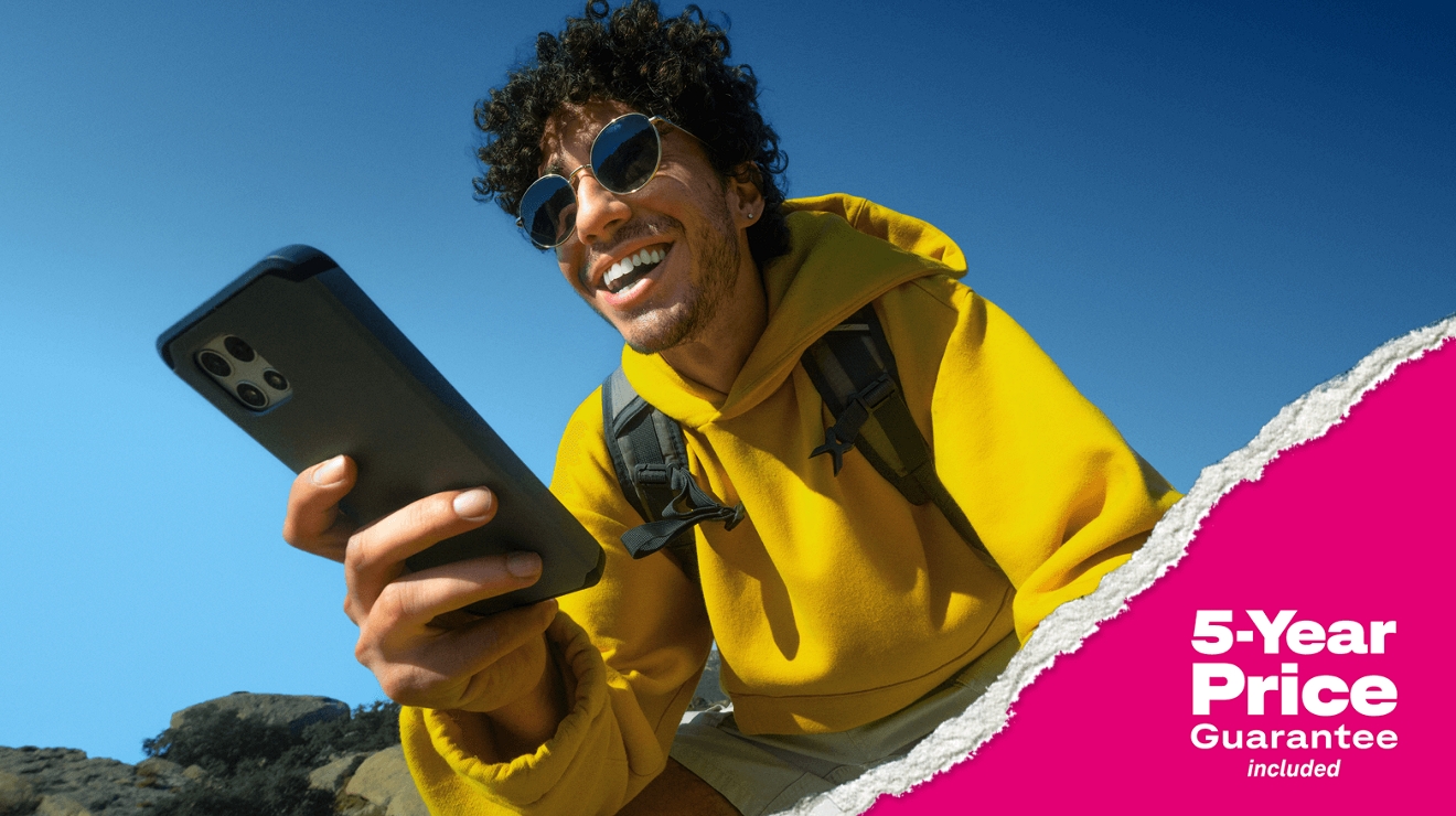 Un hombre sostiene su smartphone. Además, incluye precio garantizado por 5 años.