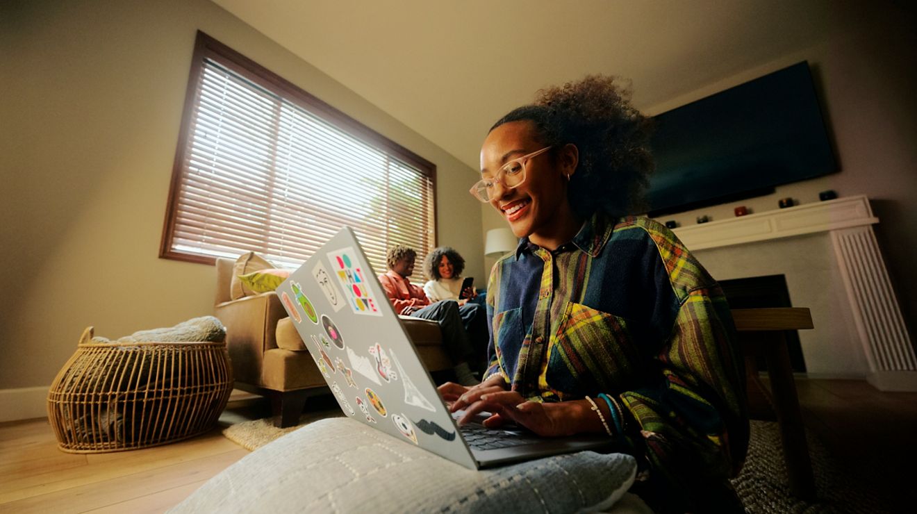 Una estudiante trabaja con una laptop en su habitación de la universidad.