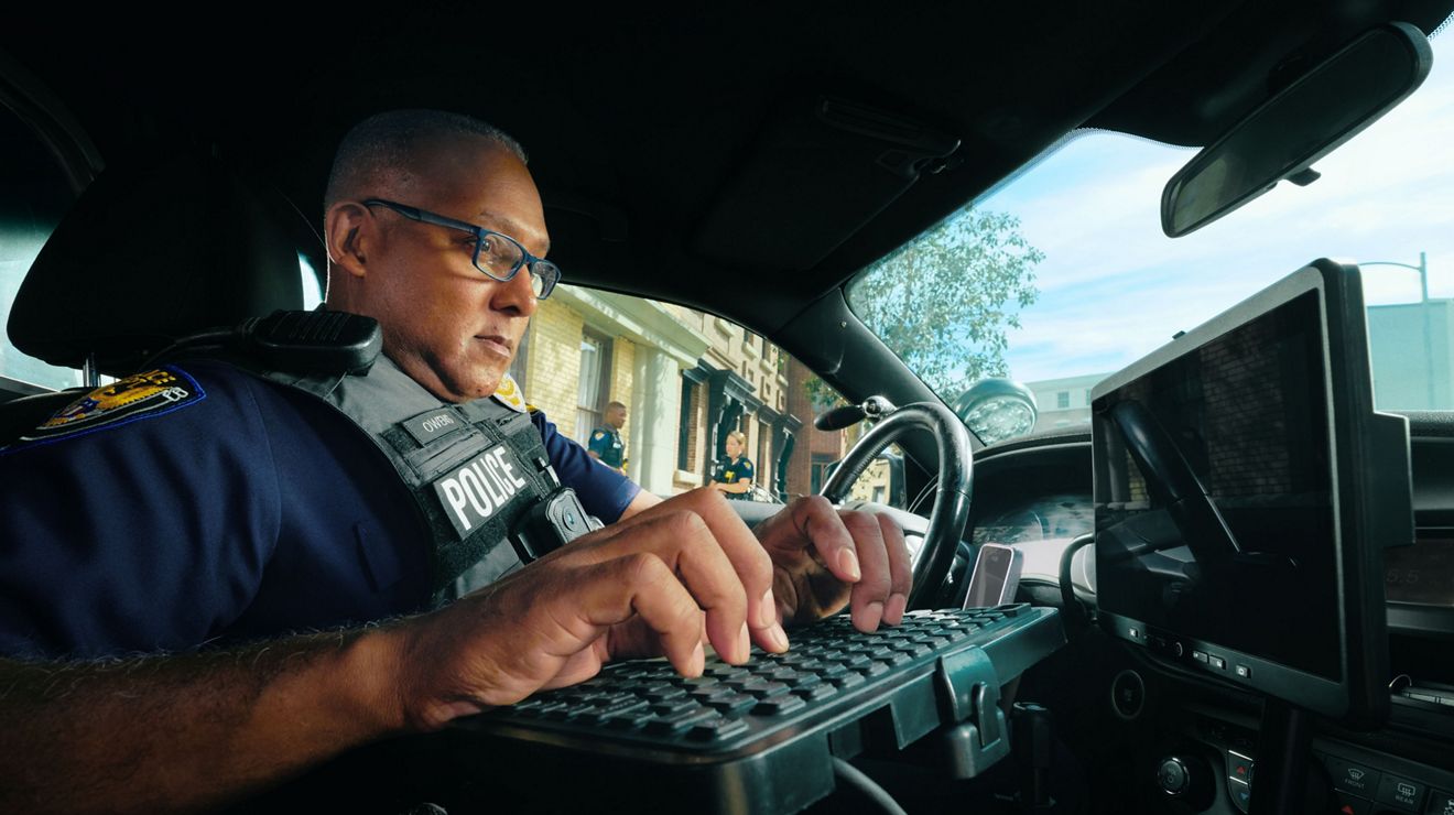 Agente usando la computadora en el auto