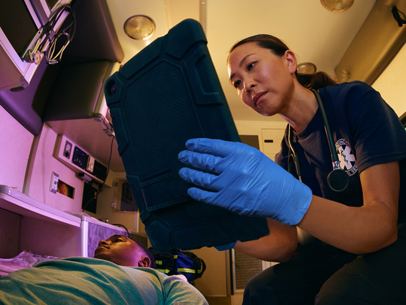 Técnico médico de emergencia con tablet en ambulancia