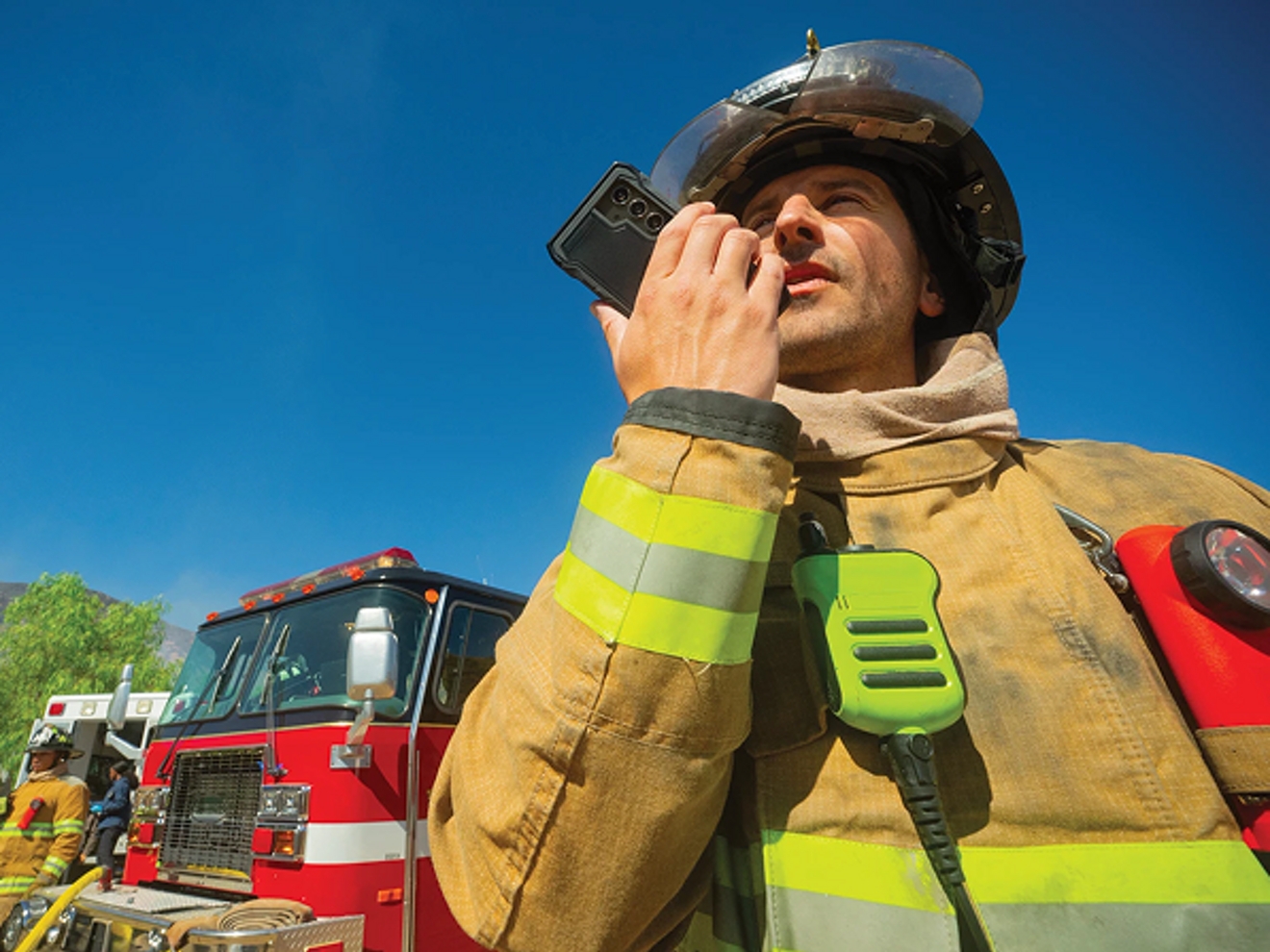 Bombero hablando por radio delante del camión
