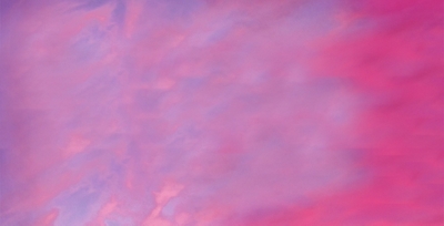 Cielo con nubes rosadas y moradas, con un avión de Alaska Airlines volando a lo lejos