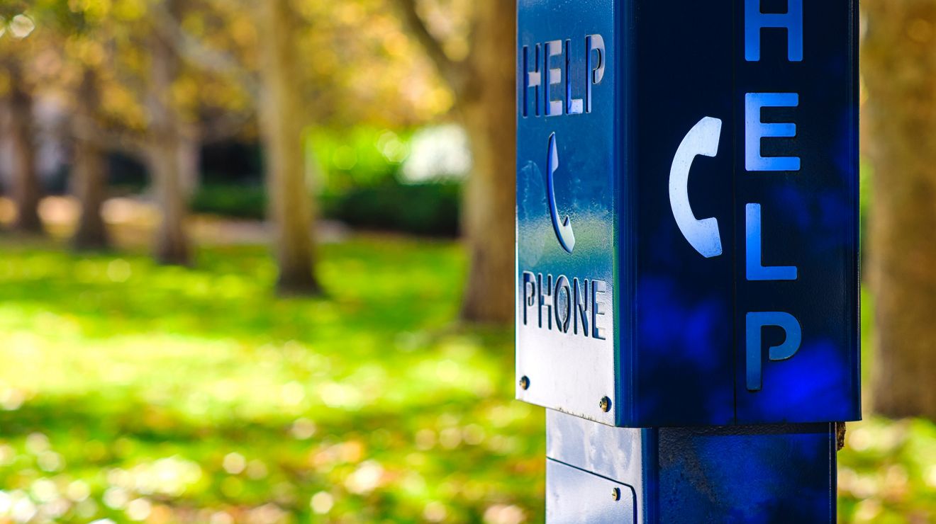 Una cabina telefónica azul de emergencia con la inscripción "HELP" en un campus universitario de Melbourne, Australia.