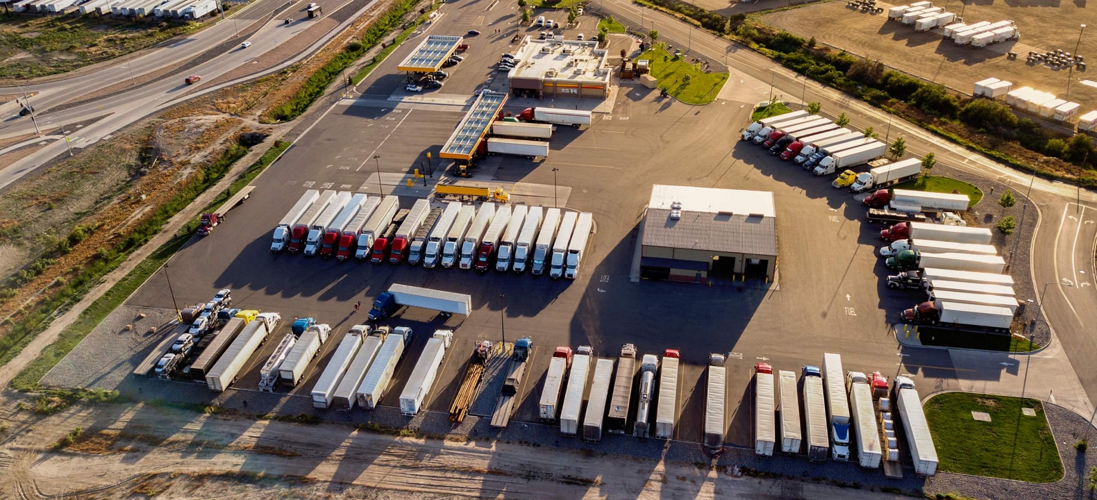 Filas de camiones semirremolques equipados con seguimiento GPS para la optimización de la flota.