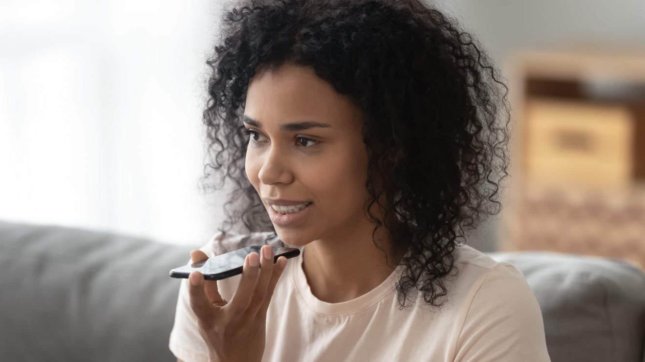 Una empresaria se comunica con un grupo de conversación a través del servicio Direct Connect Push-to-Talk en su teléfono.