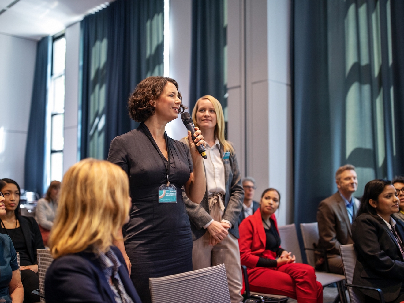 Una mujer hablando con un grupo de personas con un micrófono.